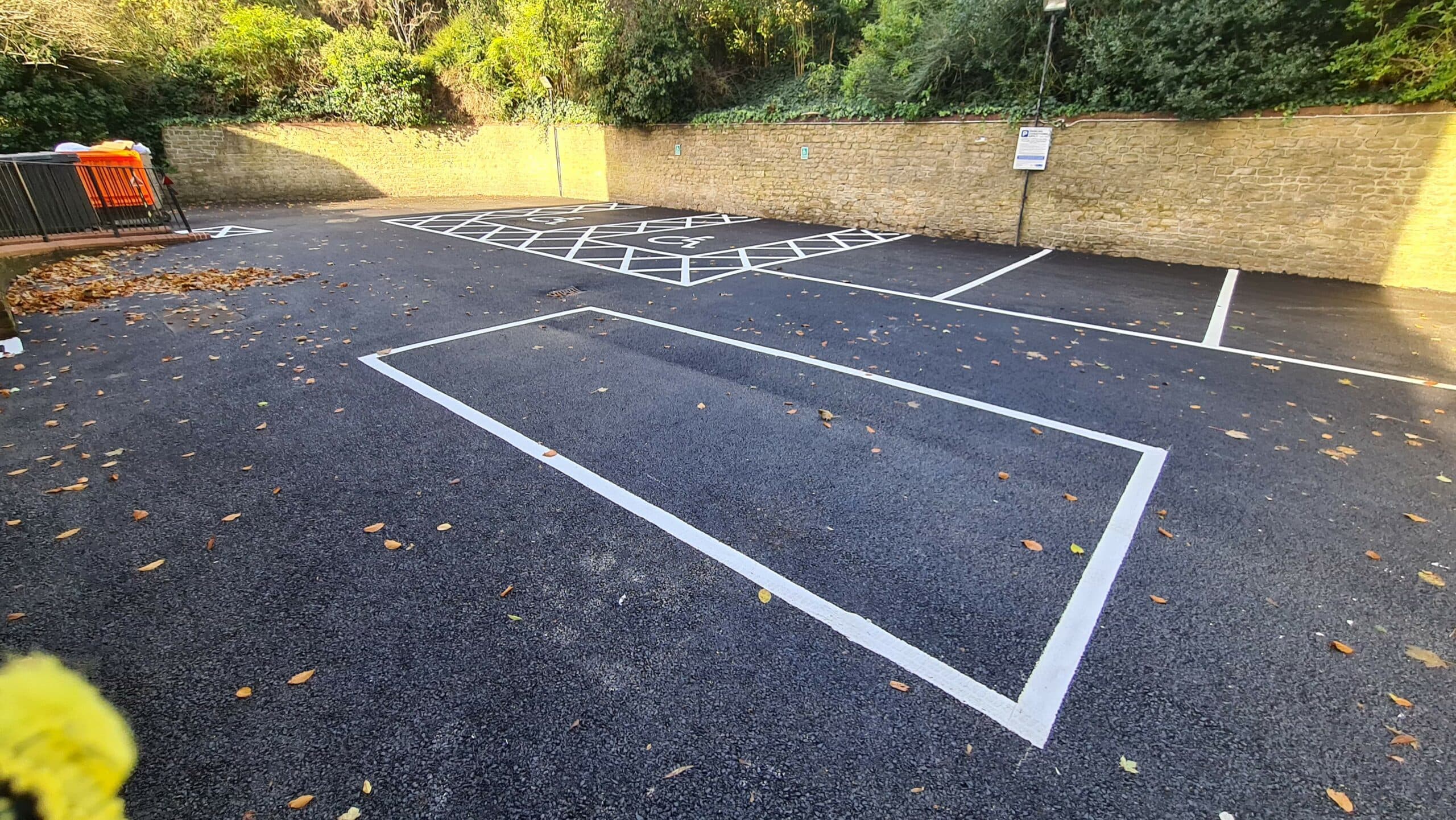 Wide view of sealed asphalt parking area with crisp white bay markings
